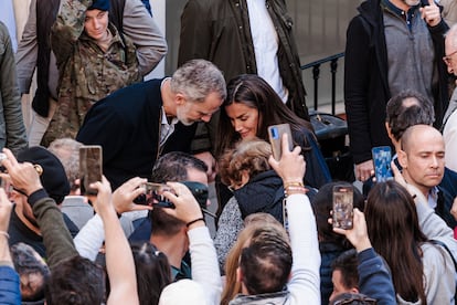 Los reyes Felipe VI y Letizia saludan a los vecinos durante la visita.