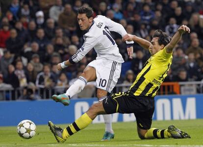 &Ouml;zil golpea el bal&oacute;n ante el jugador del Borussia Mats Hummels.