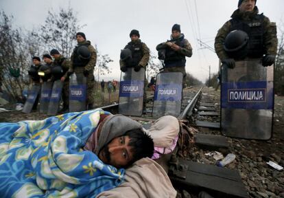 Un migrante iraní en huelga de hambre frente a la policía antidisturbios de Macedonia, en la frontera entre Grecia y Macedonia.