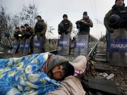 Un migrante iraní en huelga de hambre frente a la policía antidisturbios de Macedonia, en la frontera entre Grecia y Macedonia.