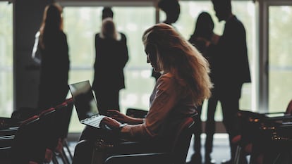 Una mujer escribe en un espacio de trabajo.