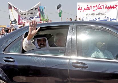 El emir de Catar saluda desde el coche junto al primer ministro palestino, Ismail Haniya, en Gaza.