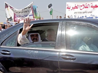 El emir de Catar saluda desde el coche junto al primer ministro palestino, Ismail Haniya, en Gaza.