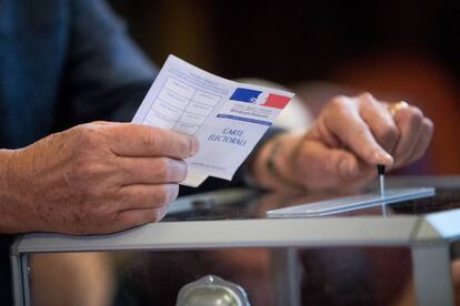 Un votante emitiendo su voto en un colegio electoral en Francia.