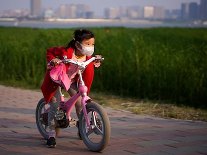 Una niña monta en bicicleta en un parque de Wuhan (China).