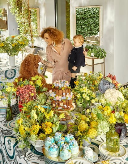 La pintora Bárbara Pan de Soraluce reconoce que de joven trabajó unos cinco minutos y luego, durante 35 años, fue “mujer florero”. Hace ocho años se lanzó a dibujar a mano platos a plumilla, personalizados, en loza y porcelana de Limoges. Así nació su propia marca de vajillas, Los Platos de Pan, que rinden tributo al jardín de su casa de Madrid y a la botánica: flores, mariposas, verduras, herramientas de jardinería… Para estas fiestas ha pensado en una merienda para su nieto Juanito y su perro Petunia, una mesa plagada de pavlovas de limón y tartas de chocolate hechas por Lacreme Madrid, la pastelería de Mónica García. La vajilla es de Los Platos de Pan, la mantelería está hecha con una tela diseñada por Pan de Soraluce para el interiorista Nacho de la Vega, y las flores son de Floreale. La pintora luce vestido de Jorge Vázquez y pendientes de Carolina Herrera, y Juanito lleva ropa de Chucu-chu.