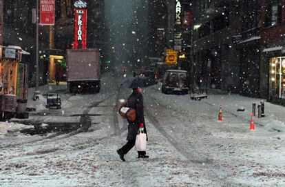 Un hombre camina por una calle nevada de Nueva York.