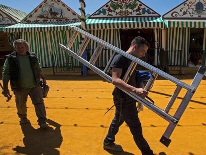 Unos operarios trabajan en los preparativos de la Feria de Abril de Sevilla del año pasado.