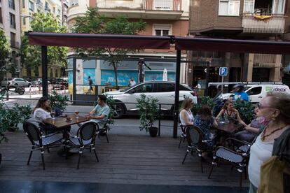 Operarios instalan un toldo en una terraza puesta en plazas de aparcamiento en la calle de Ponzano.
