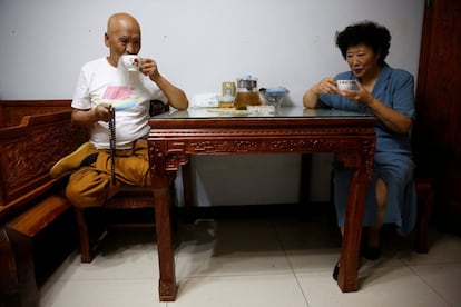 En la imagen, el maestro Li y su mujer Liang Xiaoyan beben té en su apartamento de Pekín.