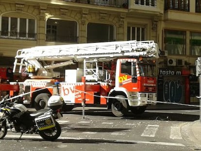 Los bomberos atienden un desprendimiento de la fachada en la avenida de María Cristina de Valencia.
