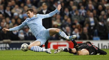 Edin Dzeko, del Manchester City, cae al suelo tras una entrada de Diego Contento en el partido de la fase de grupos en que el City vencer&iacute;a por 2 a 0.