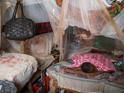 Una mujer, enferma de malaria, descansa en la cama de su familia en la barriada de Povoado en Luanda, Angola.