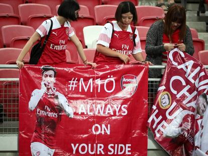 Un grupo de fans del Arsenal cuelgan un cartel de apoyo al alemán Mesut Özil durante el partido amistoso contra el Atlético de Madrid en el Estadio Nacional en Singapur.