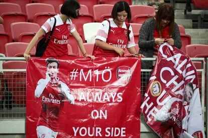Un grupo de fans del Arsenal cuelgan un cartel de apoyo al alemán Mesut Özil durante el partido amistoso contra el Atlético de Madrid en el Estadio Nacional en Singapur.