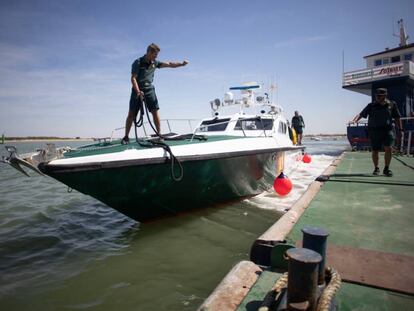 Una patrullera de la Guardia Civil suelta amarras de un embarcadero en el Guadalquivir.