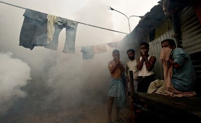 El tercer país del mundo más afectado por la malaria es India (6% de todos los casos). En la fotografía, tomada en 2010, se puede ver otra de las herramientas empleadas para combatir la pandemia: la fumigación. Los obreros que construyen el Estadio Shivaji de Nueva Delhi se cubren la cara mientras un operario municipal fumiga para prevenir las plagas de mosquitos con la llegada de los monzones.