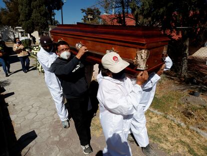 Familiares asisten al entierro de un fallecido por covid-19, en Ciudad de México.