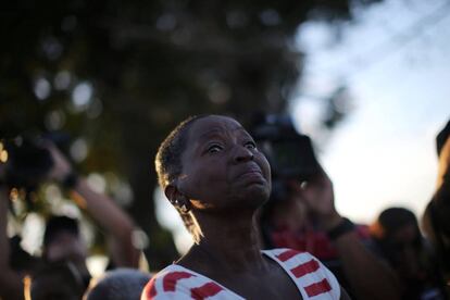 A woman looks on Fidel Castro's funeral motorcade passes by.