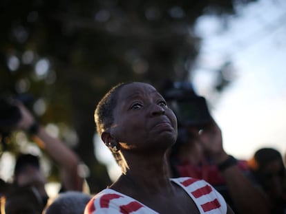 A woman looks on Fidel Castro's funeral motorcade passes by.