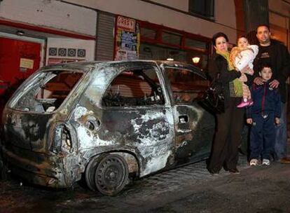Chakib, Naima y sus hijos, frente a su coche, que fue incendiado en la calle de Embajadores.