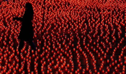 Una mujer coloca velas durante un acto solidario, en Berna (Suiza).