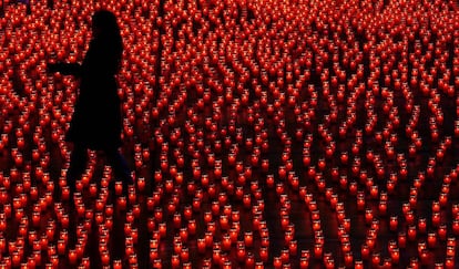 Una mujer coloca velas durante un acto solidario, en Berna (Suiza). 