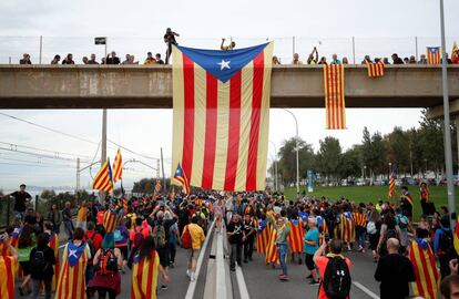 Una bandera estelada cuelga de un paso elevado cercano a la localidad barcelonesa de El Masnou, mientras los manifestantes marchan durante la huelga general en Cataluña, este viernes.