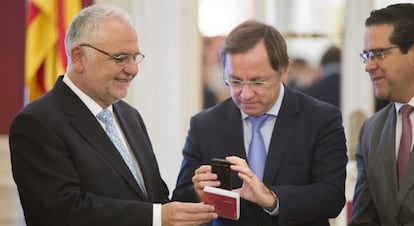 El presidente de las Cortes, a la izquierda, recibe los presupuestos de la Generalitat del consejero de Hacienda, en el centro.