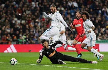El delantero del Real Madrid Karim Benzema salta sobre Gerónimo Rulli, portero de la Real Sociedad, en una jugada en la primera parte del partido de hoy en el Bernabeu.