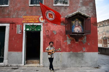 Indonesian musician Ricky Surya Virgana performs in front of the Communist Party 's local office in a street of Venice on May 6, 2015. AFP PHOTO / GABRIEL BOUYS