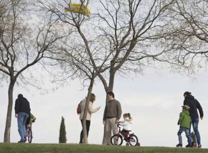 Varios niños juegan con bicicletas y patines en el Campo de las Naciones.