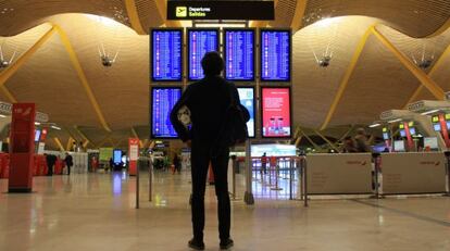 Un joven observa la pantalla de salidas en el aeropuerto de Barajas.