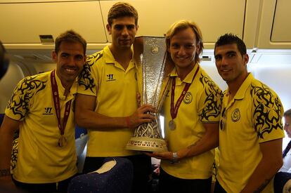 Navarro, Fazio, Rakitic y Reyes, los capitanes, posan con el trofeo de campeones.