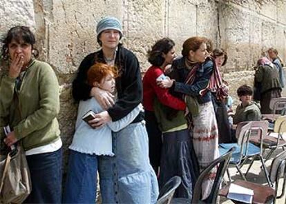 Varios israelíes se protegen en el Muro de las Lamentaciones durante los choques entre palestinos y policías.