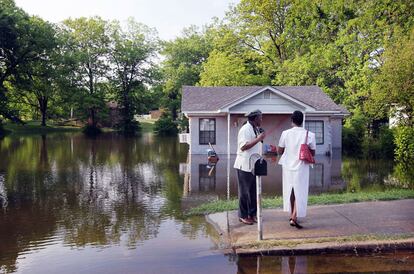Un grupo de residentes observa una casa anegada por el agua, en Memphis.