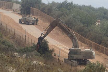 Una grúa israelí operada por soldados trabaja en la frontera con Líbano cerca del lugar en el que ayer se produjo el enfrentamiento.