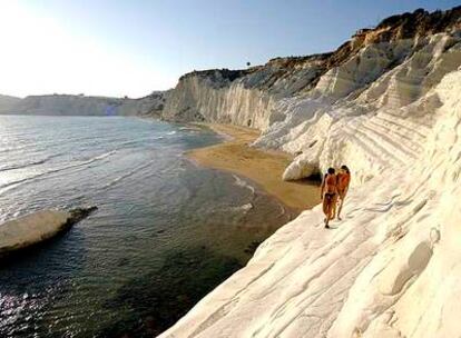 Dos bañistas pasean por las terrazas calcáreas de la Scala dei Turchi, al sur de la isla de Sicilia, cerca de Agrigento.