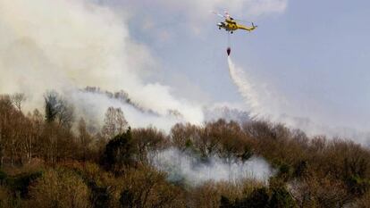 Un helic&oacute;ptero trata de sofocar el fuego que arras&oacute; ayer bosques del municipio lucense de Samos.