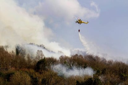 Un helic&oacute;ptero trata de sofocar el fuego que arras&oacute; ayer bosques del municipio lucense de Samos.