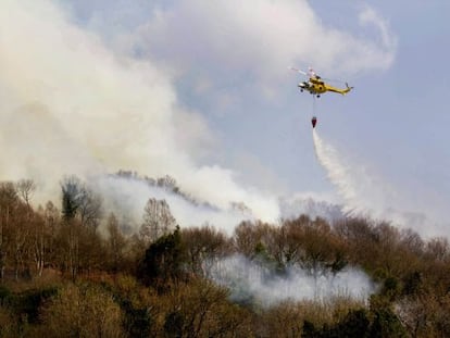 Un helic&oacute;ptero trata de sofocar el fuego que arras&oacute; ayer bosques del municipio lucense de Samos.