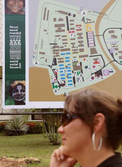 Una mujer pasa junto al plano con las actividades del foro.