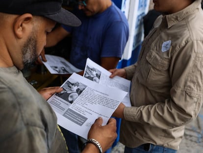 Tres hombres analizan la ficha de búsqueda de una persona desaparecida, en el Estado de Jalisco, en agosto de 2023.