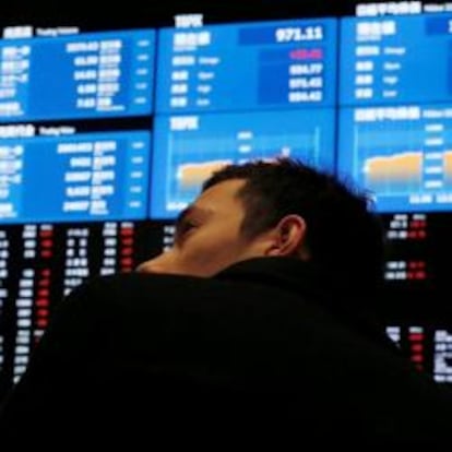 Imagen de un hombre mirando un panel de cotizaciones en la Bolsa de Tokio.