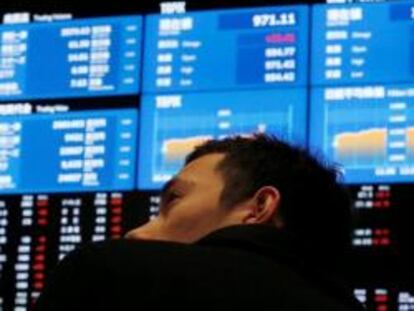 Imagen de un hombre mirando un panel de cotizaciones en la Bolsa de Tokio.