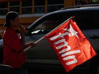 Un simpatizante porta una bandera del FMLN, durante un mitin de cierre de campaña en San Salvador, el 27 de enero de 2024.