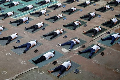 Agentes de la policía de Bangladés participan en una sesión de yoga para estimular su sistema inmunológico mientras continúa el brote de coronavirus, en Daca.