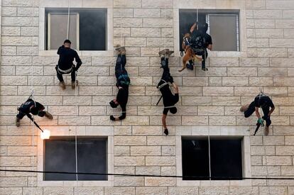 Miembros palestinos de las fuerzas de seguridad de Hamás practican rápel a lo largo del muro de un edificio, durante una ceremonia de graduación de la policía en la ciudad de Gaza.