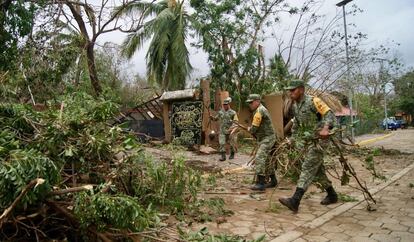 Uno grupo de militares despejan un camino cubierto por ramas de árboles caídos en el municipio oaxaqueño de Santa María Tonameca, uno de los más afectados por el paso del huracán 'Agatha'.