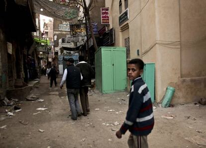 Varios jóvenes pasan junto a un local utilizado para practicar ablaciones, en el área de Giza.